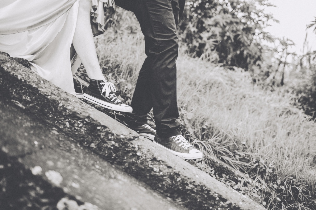 Una pareja con zapatillas Converse desciende por unas escaleras de piedra en una foto de photo-nic.co.uk nic en Unsplash